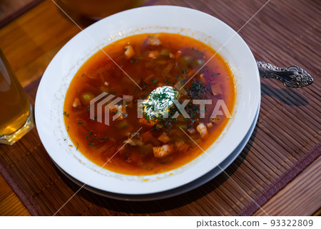 Traditional Russian meat soup Solyanka with sour cream and lemon 93322809