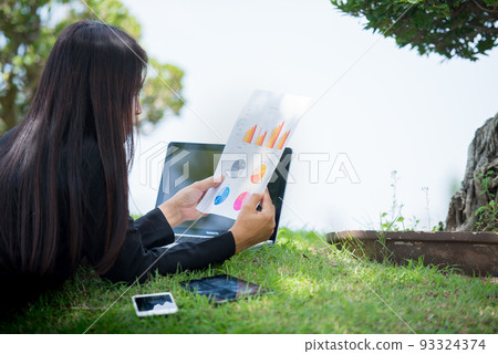 Asian entrepreneur business woman reading business graph analyze chart using laptop on green garden at home. Freelance working home office social distance new normal lifestyle in open cafe green park Asian entrepreneur business woman reading business graph analyze chart using laptop on green garden at home. Freelance working home office social distance new normal lifestyle in open cafe green park 93324374