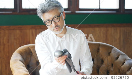 Middle-aged man polishing a golf club Middle-aged man polishing a golf club 93326750