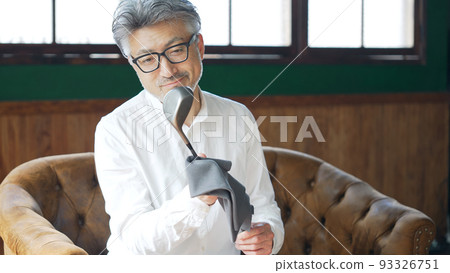擦亮高爾夫球桿的中年男子 93326751