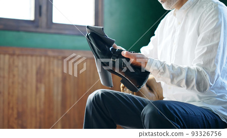 man polishing leather shoes 93326756