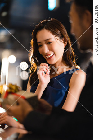 留鬍子的男人在酒吧給一個漂亮的女人送禮物 93329186