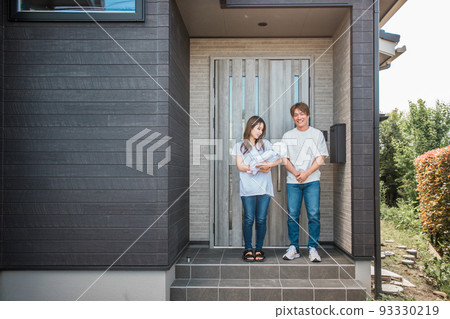 Asian couple/family standing at the entrance of a new house 93330219