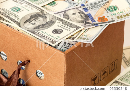 Cardboard box full of dollars. 93330248