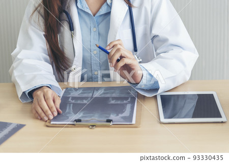 Close up hands of women doctor write prescription medical lab hospital. Crop asian women hand doctors working in medical clinic looking CAT scan xray film. Doctor with stethoscope writing on notepad Close up hands of women doctor write prescription medical lab hospital. Crop asian women hand doctors working in medical clinic looking CAT scan xray film. Doctor with stethoscope writing on notepad 93330435