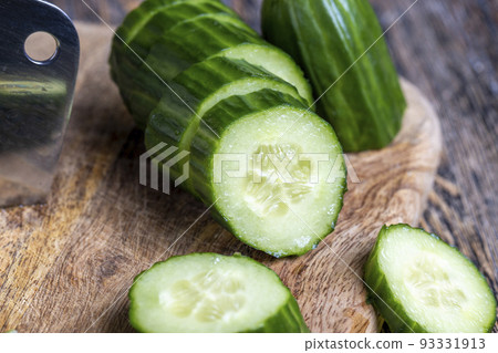 Sliced green cucumber while cooking salad 93331913