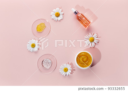 Cosmetic products on pink background. Natural care cosmetic swatch with chamomile Cosmetic products on pink background. Natural care cosmetic swatch with chamomile 93332655