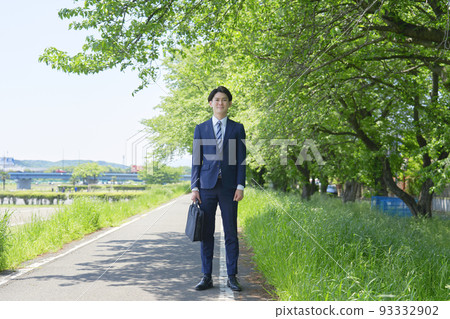 站在新鮮綠色植物中的商人的全身肖像 93332902