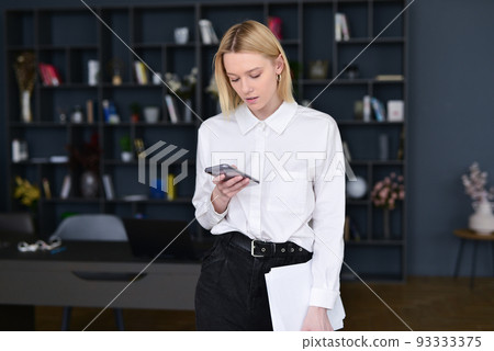 Business woman looking at her smartphone 93333375