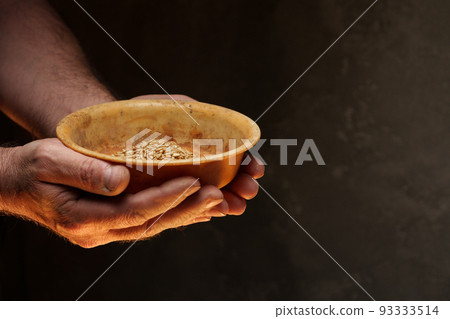 Close up of male hands holding small amount of wheat seeds. Lack of food and hunger concept 93333514