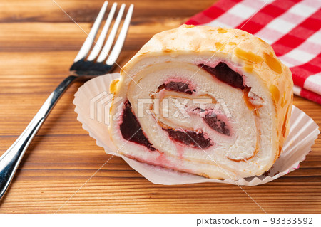Meringue roll cake with cream on wooden table Meringue roll cake with cream on wooden table 93333592