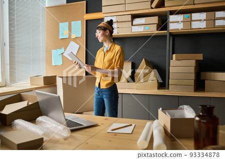 Young woman using digital tablet to distributing parcels for shipping, working in warehouse Young woman using digital tablet to distributing parcels for shipping, working in warehouse 93334878