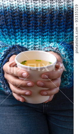 Hands holding a takeaway cup with Chicken broth soup Hands holding a takeaway cup with Chicken broth soup 93335159