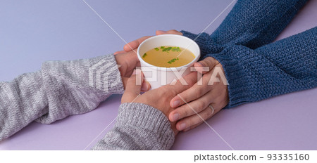 Hands holding a papern cup with broth soup Hands holding a papern cup with broth soup 93335160