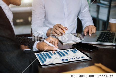 Business, technology and office concept - two businessmen with laptop, tablet pc computer and papers having discussion in modern office. Business, technology and office concept - two businessmen with laptop, tablet pc computer and papers having discussion in modern office. 93335236