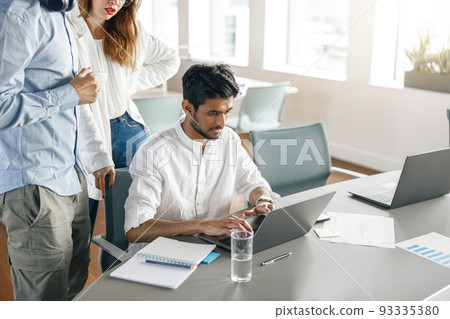 Group of young diverse coworkers analyzing sales report while working together in the office 93335380