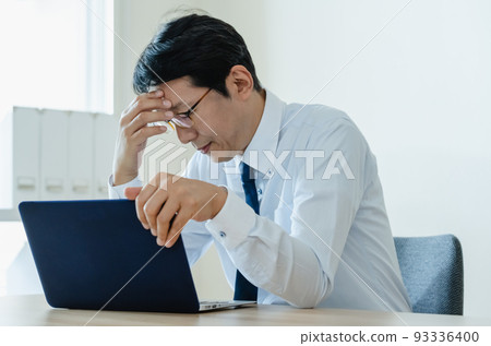 Middle-aged businessman heading to a personal computer 93336400
