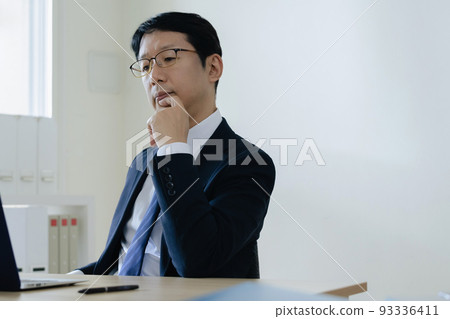Middle-aged businessman heading to a personal computer Middle-aged businessman heading to a personal computer 93336411
