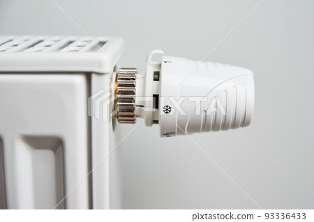 Heating radiator with temperature control knob, Energy crisis concept, Rising costs in private households for gas bill due to inflation and war Heating radiator with temperature control knob, Energy crisis concept, Rising costs in private households for gas bill due to inflation and war 93336433