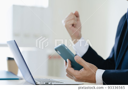 Middle-aged businessman looking at smartphone 93336565