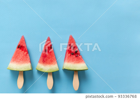 Fruit ice cream. Summer watermelon slice popsicles on blue background. Design for cover, wallpaper, device screen Fruit ice cream. Summer watermelon slice popsicles on blue background. Design for cover, wallpaper, device screen 93336768