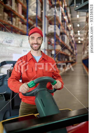 Cheerful worker moving merchandise around the storehouse Cheerful worker moving merchandise around the storehouse 93336928