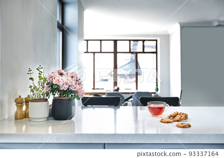 Breakfast scene at sunny morning. Transparent black tea mug with biscuit on kitchen table Breakfast scene at sunny morning. Transparent black tea mug with biscuit on kitchen table 93337164