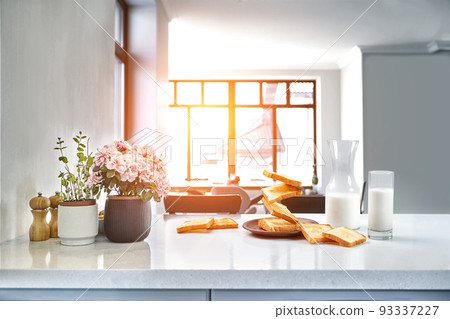Served table for breakfast with toast, milk and honey, on blurred background. Sun flare 93337227