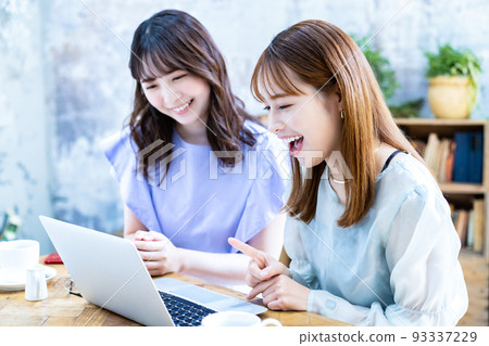 Two young women planning a trip Two young women planning a trip 93337229