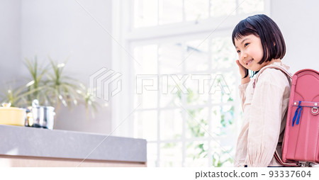 Elementary school student carrying a school bag waving 93337604