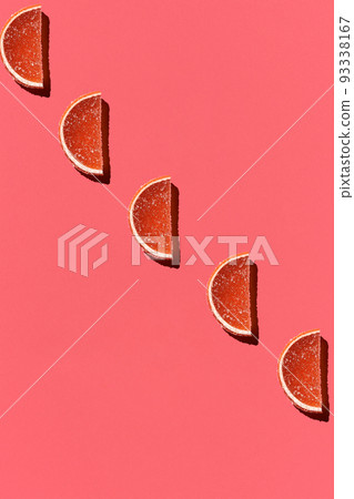 Pattern made of colorful candied fruits orange lemon on coral background. Flat lay. Minimal concept Pattern made of colorful candied fruits orange lemon on coral background. Flat lay. Minimal concept 93338167