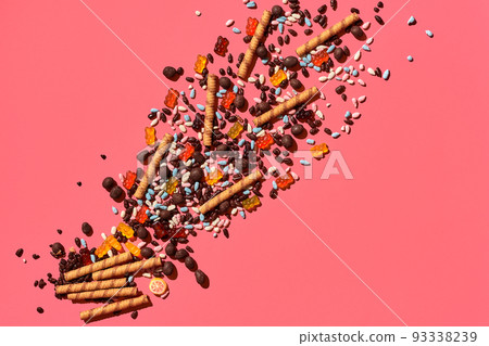 A heap of delicious sweets explode from the corner of image to the top, view from above. From left to the right direction 93338239