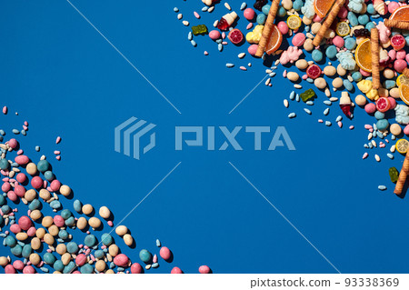 Photo of dragee candies placed on the opposite corners of image with a copy space in the middle Photo of dragee candies placed on the opposite corners of image with a copy space in the middle 93338369