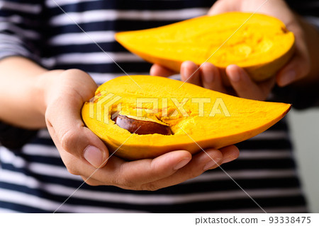 Canistel fruit or Eggfruit holding by woman hand, Tropical fruit 93338475