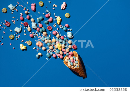 An image of a heap of dragee sweets that is sprinkled from a waffle cone 93338868