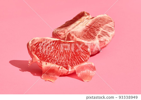 Close up high quality image of peeled slices of juicy grapefruit on a pink background Close up high quality image of peeled slices of juicy grapefruit on a pink background 93338949