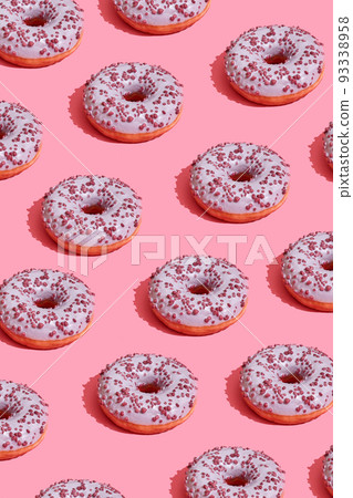 Food design with tasty pink glazed donut on coral pink pastel background top view pattern 93338958