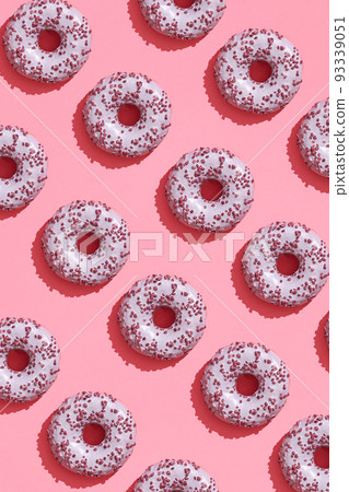 Food design with tasty pink glazed donut on coral pink pastel background top view pattern 93339051