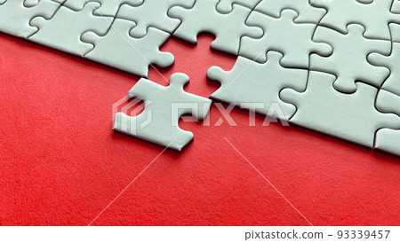 Jigsaw puzzle on red background with customizable space for text or ideas. Copy space Jigsaw puzzle on red background with customizable space for text or ideas. Copy space 93339457