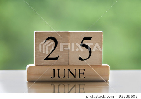 June 25 calendar date text on wooden blocks with blurred nature background. Copy space and calendar concept 93339605