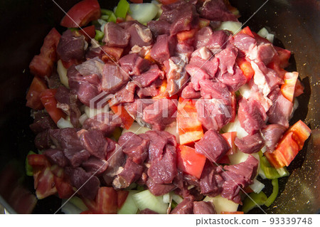 Metal stock pot with soup ingredients vegetables and meat Metal stock pot with soup ingredients vegetables and meat 93339748