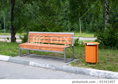 Wooden bench and garbage can in the park 93341467