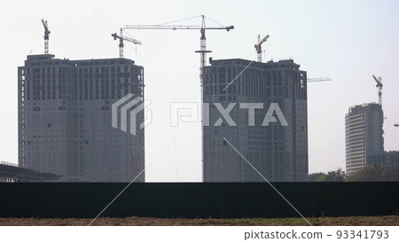 Building construction of many high rise skyscrappers. Gray sky background. 93341793