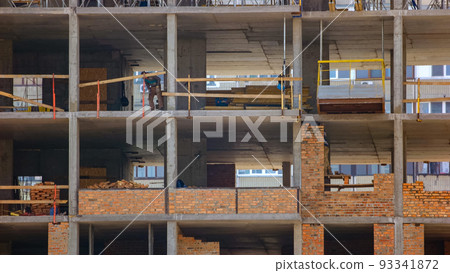 Skyscrapper building construction workers in different rooms. Workers divided by concrete walls. 93341872