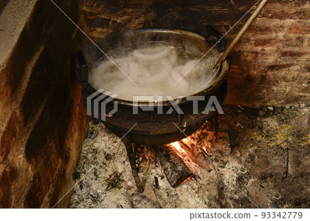 Cooking white blood sausage, in an iron saucepan, on a stove. 93342779