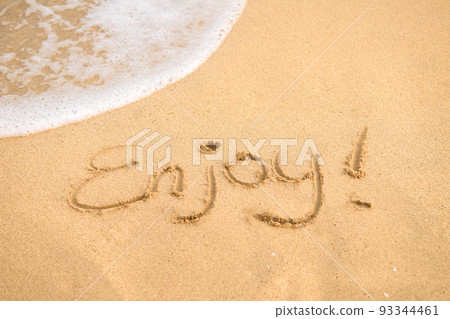 Word Enjoy written on the sand 93344461