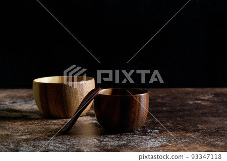 Two japanese style wooden bowl with wooden spoon on dark grunge brown background with copy space Two japanese style wooden bowl with wooden spoon on dark grunge brown background with copy space 93347118