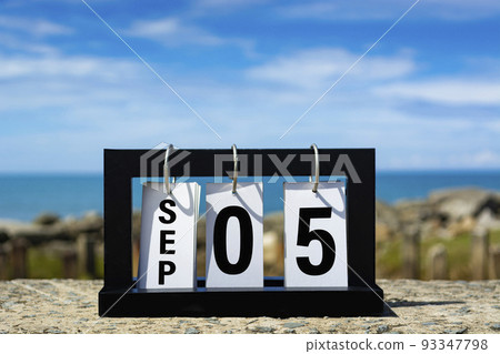 Sep 05 calendar date text on wooden frame with blurred background of ocean. Sep 05 calendar date text on wooden frame with blurred background of ocean. 93347798