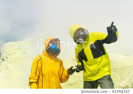 volcano scientists on the slope of the volcano collect samples of minerals against the backdrop of smoking sulfur fumaroles volcano scientists on the slope of the volcano collect samples of minerals against the backdrop of smoking sulfur fumaroles 93348287