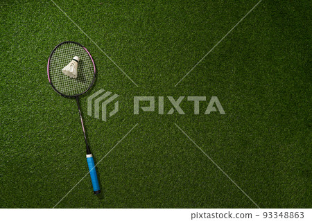 Badminton racket and shuttlecock on green grass background. Badminton racket and shuttlecock on green grass background. 93348863